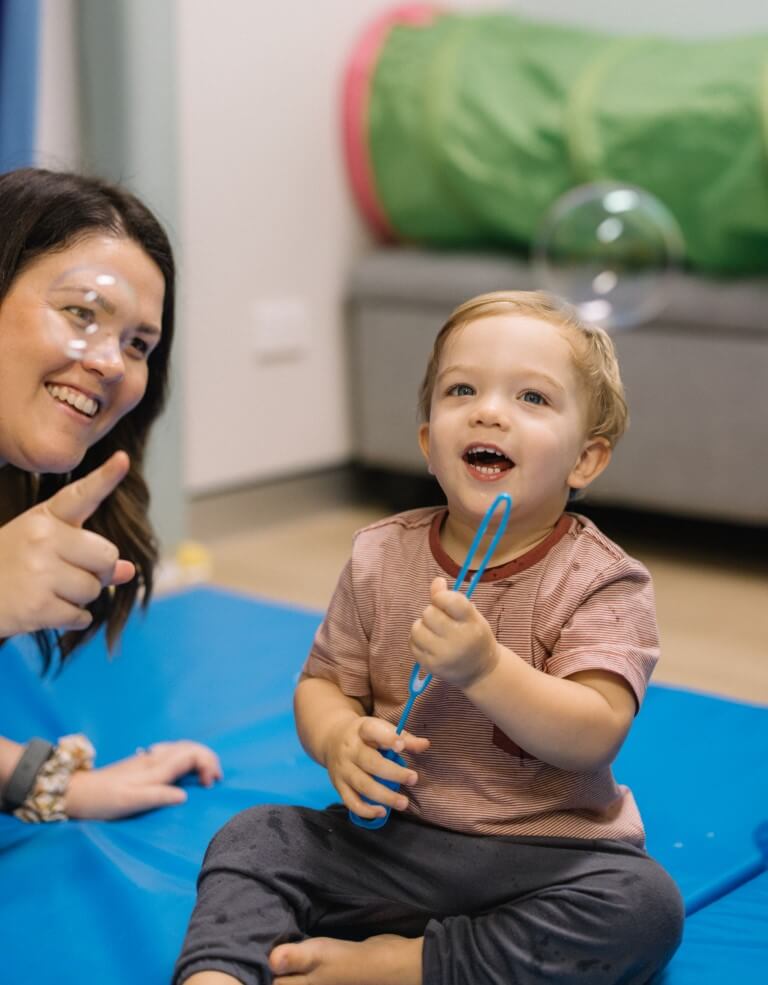 Jenna with boy blowing bubbles