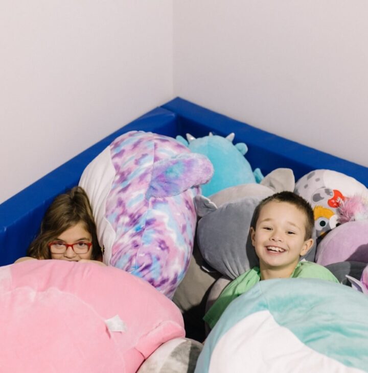 Boy and girl lying in squishmallow pit